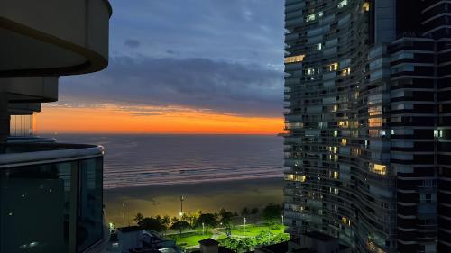 a view of the ocean at sunset from a building at Estanconfor Vista Mar em Santos in Santos