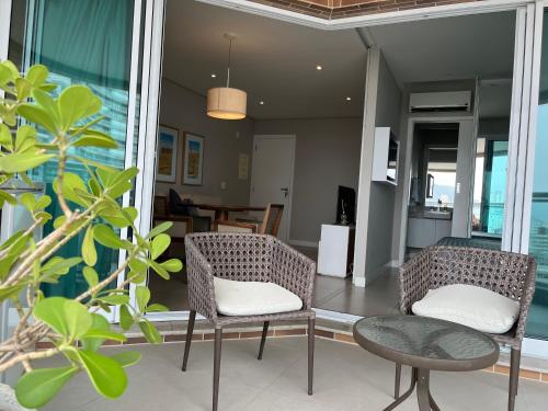 a living room with two chairs and a table at Estanconfor Vista Mar em Santos in Santos