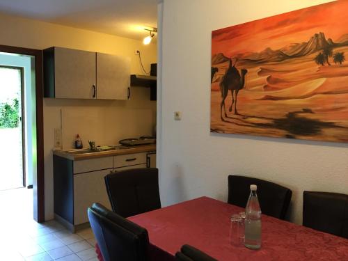 a dining room with a table and a painting on the wall at Wolterdinger Hof in Soltau