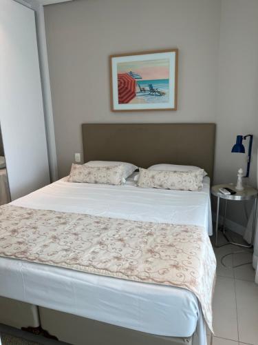 sypialnia z 2 białymi łóżkami z obrazem na ścianie w obiekcie Estanconfor Vista Mar em Santos w mieście Santos