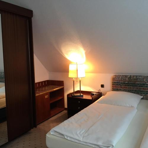 a bedroom with a bed and a lamp on a night stand at Wolterdinger Hof in Soltau