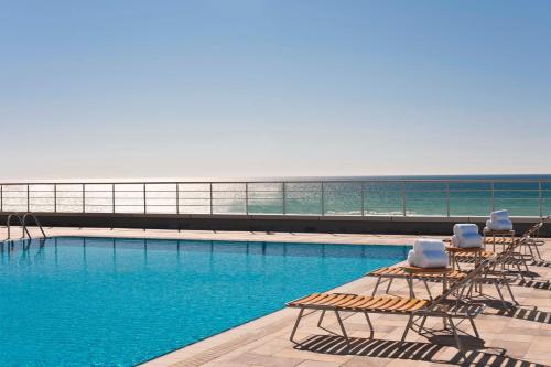 a swimming pool with lounge chairs on top of a building at Renaissance by Sulo in Aktau