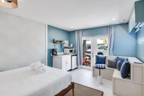 a bedroom with a white bed and blue walls at Caloosa Retreat- 2BR at Palmview Inn Sanibel in Sanibel