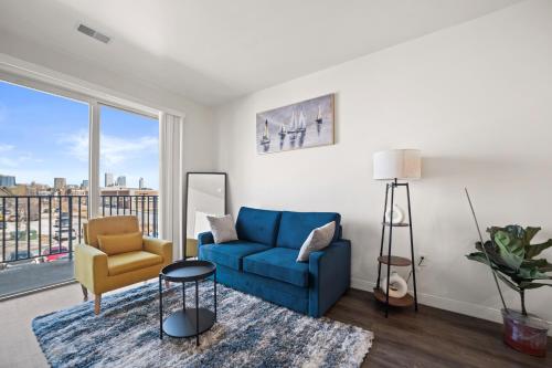 a living room with a blue couch and a chair at Riverside Plaza Blue in Milwaukee