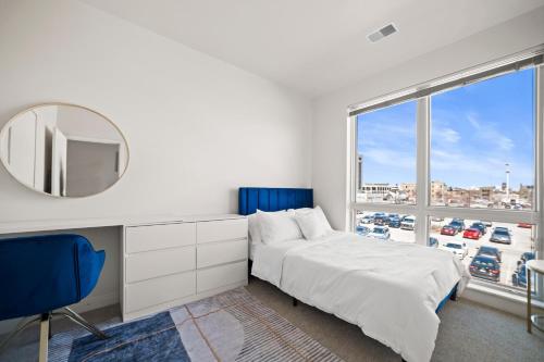 een slaapkamer met een bed, een spiegel en een raam bij Riverside Plaza Blue in Milwaukee