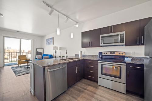 a kitchen with stainless steel appliances and a living room at Riverside Plaza Blue in Milwaukee
