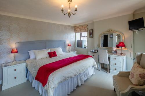 a bedroom with a bed and a desk and a chair at East Hook Farmhouse in Haverfordwest