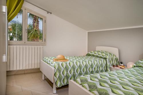 a bedroom with two beds and a window at Villa Jacqueline con piscina privata 8 posti letto in Scopello