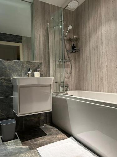 a bathroom with a tub and a sink and a shower at Luxury Manchester Arena Apartment by Cloud Suites in Manchester