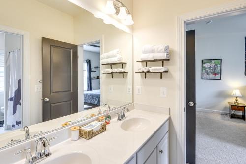a bathroom with two sinks and a large mirror at Lakefront Fredericksburg Home with Deck and Fire Pits! in Fredericksburg