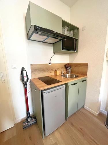 Il comprend une petite cuisine avec un évier et un aspirateur. dans l'établissement cosy studio au coeur du Mourillon, à Toulon