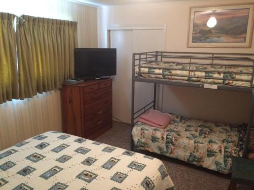 1 dormitorio con 2 literas y TV en River House in Welches on Mt Hood OR, en Welches