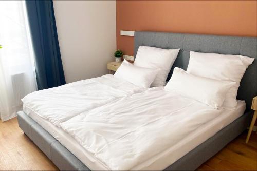 1 cama grande con sábanas y almohadas blancas en Großzügiges City-Apartment in Mönchengladbach en Mönchengladbach