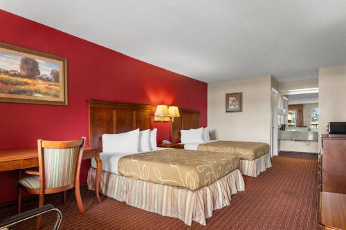 a hotel room with two beds and a desk at Americas Best Value Inn-Montezuma in Montezuma