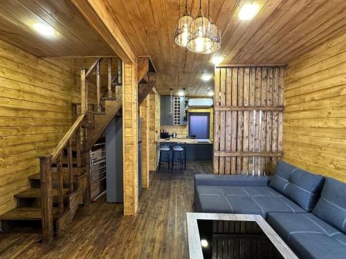 a living room with a blue couch and wooden walls at Swiss House Dilijan in Dilijan