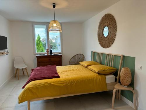 - une chambre avec un lit jaune et un miroir dans l'établissement Villa d’Isaure, à Bergerac