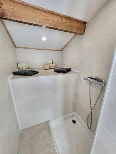 La salle de bains blanche est pourvue de toilettes. dans l'établissement Le studio, à Béhoust