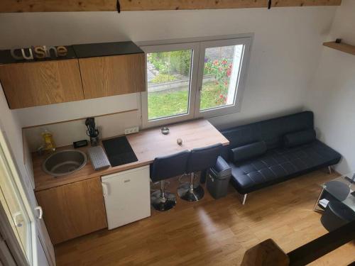 eine Küche mit Sofa und Waschbecken in einem Zimmer in der Unterkunft Le studio in Béhoust