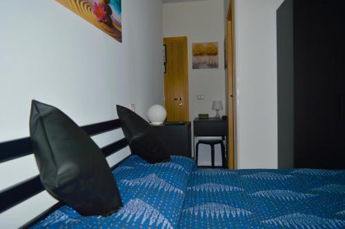 a bedroom with a blue bed with black pillows at B&B SERENITY2024 in Rome