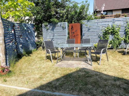 a table and chairs in a backyard with a fence at Schönes Appartement in Zierzow mit Grill, Terrasse und Garten in Sietow
