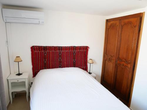 une chambre avec un lit blanc et une tête de lit rouge dans l'établissement Right by the Sea • Les Embruns, à Martigues