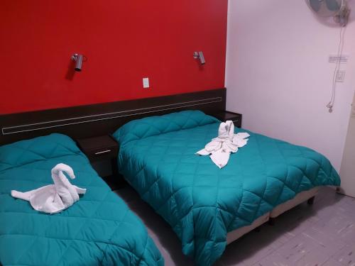 a bedroom with two beds and a stuffed animal at Hotel Sol y Sierras in La Falda