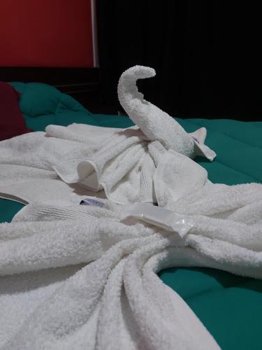 a pile of white towels on a bed at Hotel Sol y Sierras in La Falda