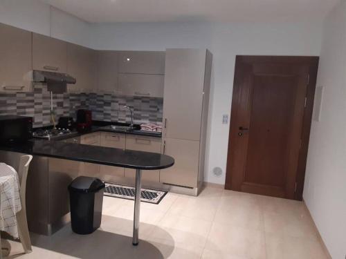 uma cozinha com uma mesa, um balcão e uma porta em Appartement S2 Palm Lake Folla - Monastir em Monastir