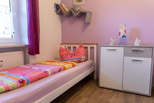 a childs bedroom with a bed and a dresser at Ferienwohnung mit zwei Schlafzimmern und Balkon - b56485 in Weißenstadt