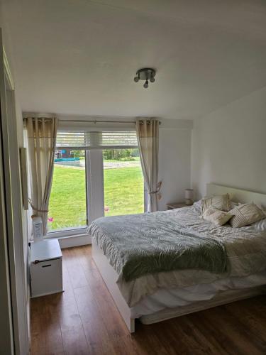 a bedroom with a bed and a large window at Remarkable 1-Bed Cabin in Dunmow in Great Dunmow