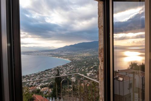 a view of a city and the ocean from a window at Orithyia prime living in Kalamata