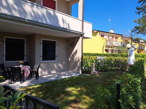 a patio of a house with a table and chairs at Adriella apartments in Bibione