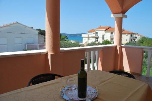 - une bouteille de vin assise sur une table sur un balcon dans l'établissement Ferienwohnung für vier Personen mit Balkon - b58114, à Sukošan