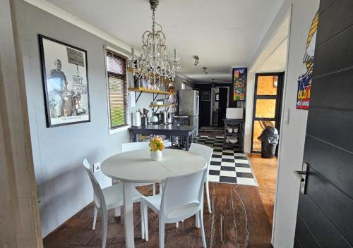 a dining room with a white table and chairs at Cloud 9 Estate - Chalet in Knysna