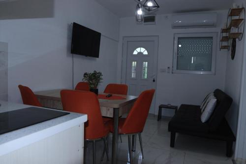 ein Wohnzimmer mit einem Tisch und roten Stühlen in der Unterkunft Apartman Lile Raca in Ohrid