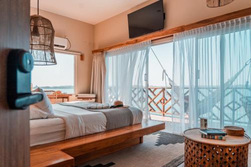 Schlafzimmer mit einem Bett und einem großen Fenster mit einem Balkon in der Unterkunft Bambuda Bocas Town in Bocas del Toro