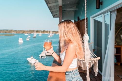 a woman holding a glass of wine overlooking the water at Bambuda Bocas Town in Bocas Town