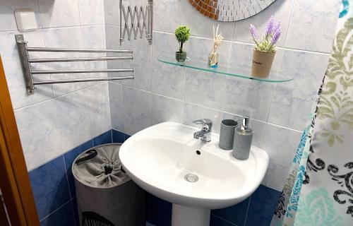 a bathroom with a sink and some plants on the wall at Posidi cosy summer retreat in Possidi