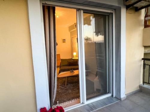 a sliding glass door of a room with a couch at Posidi cosy summer retreat in Possidi