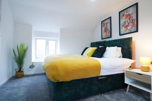 a bedroom with a large bed with a yellow blanket at Serene 3BR Cottage Escape: Parking, Kitchen, Wi-Fi in Northampton