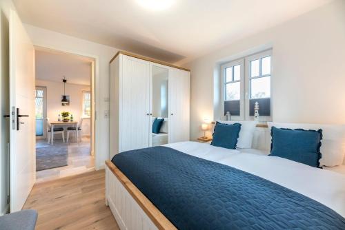 a bedroom with a large bed with blue pillows at Ankerplatz-Insel-Foehr in Oevenum