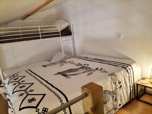 Ce lit se trouve dans une petite chambre dotée d'un couvre-lit. dans l'établissement Gîte les Romarins, à Montagnac