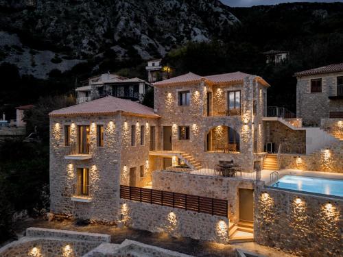 una gran casa de piedra con piscina por la noche en Orithyia prime living, en Kalamata