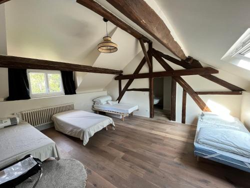 a attic room with two beds and two windows at La Passerelle in Saint-Hilarion