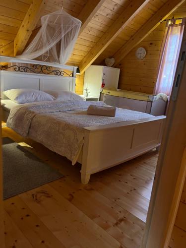a bedroom with a large bed in a cabin at Drvena kuća Marta in Belaj