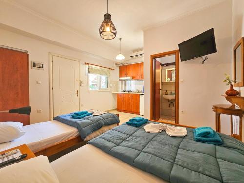 two twin beds in a room with a kitchen at Hotel Exarhos in Paralia Katerinis