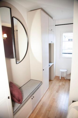 Cette petite chambre comprend un miroir et un dressing. dans l'établissement Au Cœur de Paris, à Paris