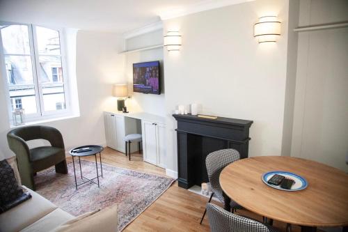 un salon avec une table et une cheminée dans l'établissement Au Cœur de Paris, à Paris