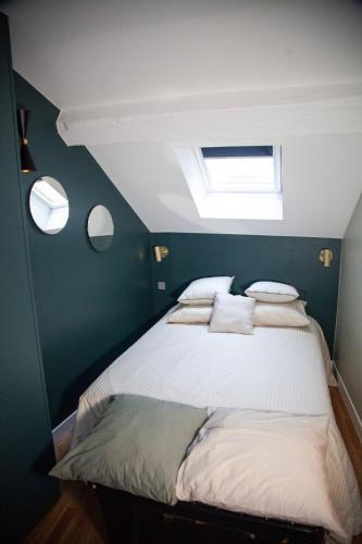 une chambre avec un lit avec des oreillers dessus dans l'établissement Au Cœur de Paris, à Paris