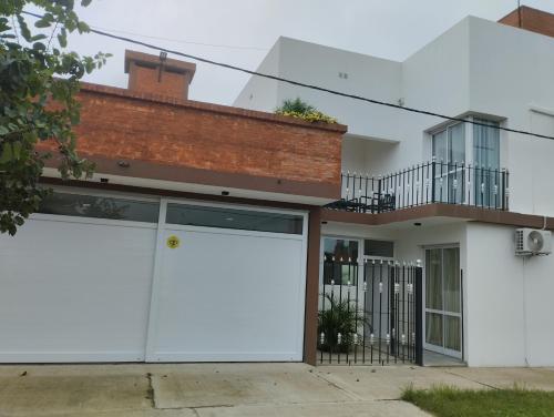 dos puertas blancas de garaje delante de una casa en Los naranjos en Reconquista